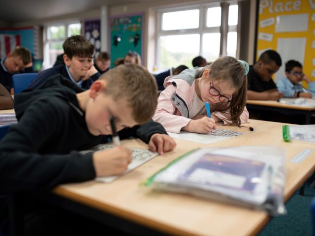 Year five pupils, with their own individual stationery and books in plastic folders, work at their desks at Willowpark Primary Academy in Oldham, northern England on September 7, 2020. - Millions of children across England have returned to school this week after the COVID-19 lockdown, with many schools introducing measures …