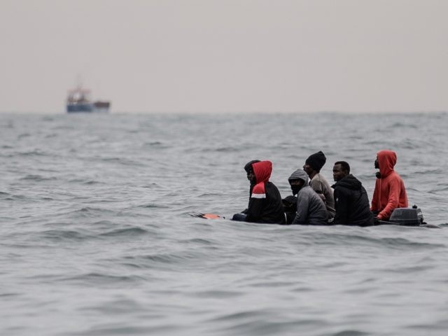 Migrants sit onboard a boat navigating in agitated waters between Sangatte and Cap Blanc-Nez (Cape White Nose), in the English Channel off the coast of northern France, as they attempt to cross the maritime borders between France and the United Kingdom on August 27, 2020. - The number of migrants …