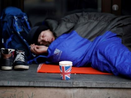 A homeless person lays in a sleeping bag on a pavement near Piccadilly Circus in central L