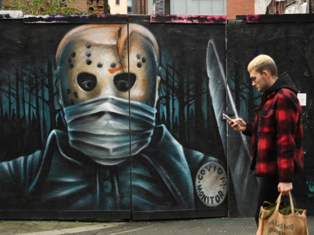 A pedestrian walks by a mural during the national coronavirus restrictions in Manchester, northwest England, on November 26, 2020. - London will escape the tightest restrictions once England's national coronavirus lockdown ends next week, the government said Thursday, but major cities including Manchester and Birmingham face at least two more …