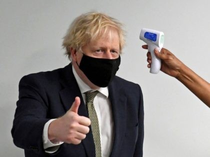 TOPSHOT - Prime Minister Boris Johnson gives a thumbs up as he has his temperature checked
