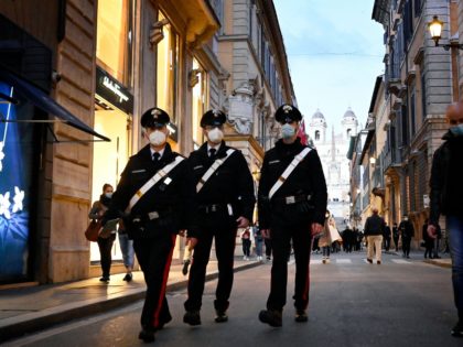 Carabinieri police officers walk across the Via dei Condotti luxury shopping street in downtown Rome on March 13, 2021 before the government tightens restrictions across most of the country from March 15, facing a "new wave" after it recorded almost 26,000 new Covid-19 cases and another 373 deaths on March …