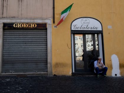 A man talks on his mobile phone in front of a closed shop in central Rome on March 15, 2021, after most of Italy re-entered into lockdown restrictions aimed at curbing the spread of the Covid-19 (novel coronavirus) pandemic. - Italy's government on March 12 announced tough new restrictions for …
