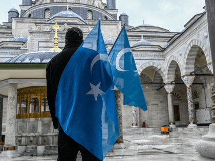 A protester from the Uyghur community living in Turkey stands with flags in the Beyazit mosque during a protest against the visit of China's Foreign Minister to Turkey, in Istanbul on March 25, 2021. - Hundreds protested against the Chinese official visit and what they allege is oppression by the …
