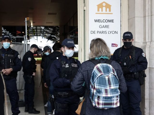 Police carry out checks on passengers at the entrance of the Lyon rail station in Paris, on March 26, 2021, to inspect their justification notes for travel after France imposed partial lockdown measures aimed at curbing the Covid-19 (novel coronavirus) pandemic. - The French government announced increased police checks on …