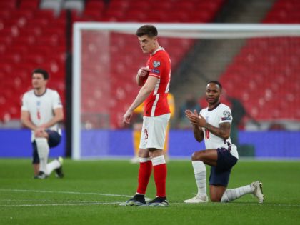England's midfielder Raheem Sterling (R) and the England players take a knee against racism as Poland's forward Krzysztof Piatek points to his 'respect' badge before kick off of the FIFA World Cup Qatar 2022 Group I qualification football match between England and Poland at Wembley Stadium in London on March …