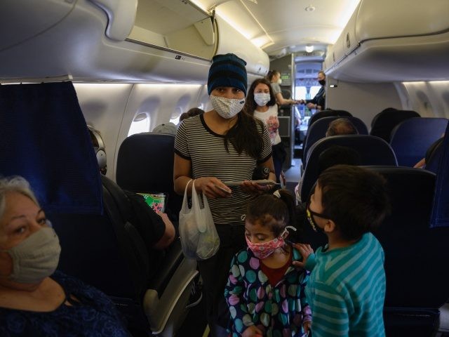 Reina (C L), Diana (C) and Dariel (R) from El Salvador board a flight on March 30, 2021 fr