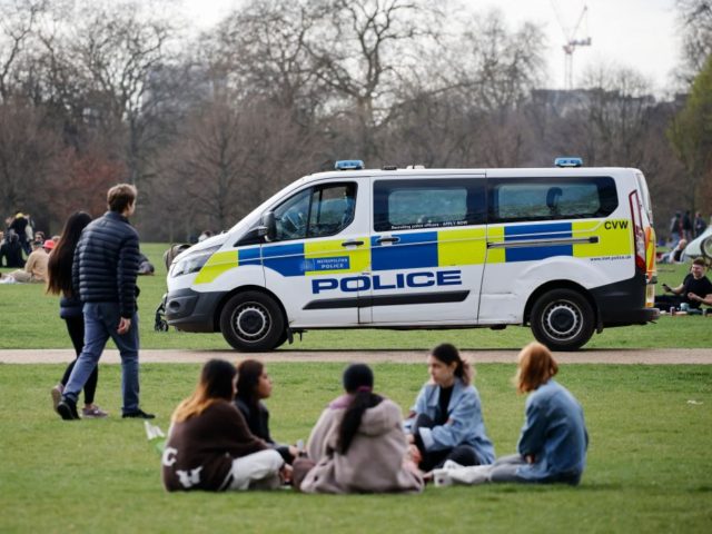 A police van patrols as people relax in Hyde Park in central London on April 2, 2021 as li