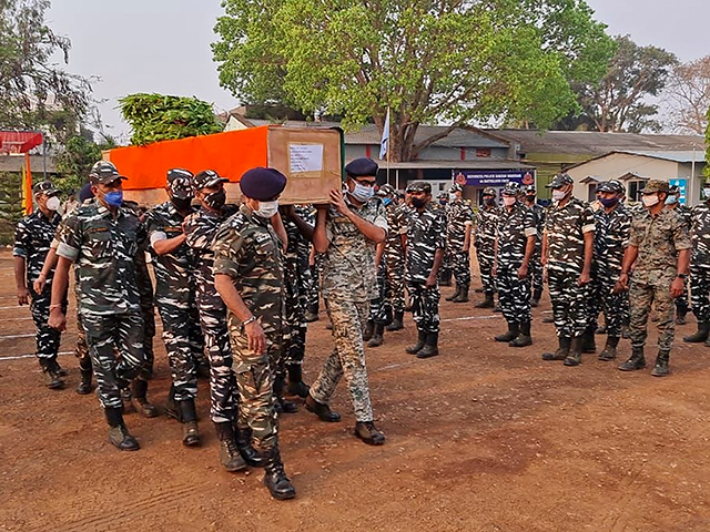 Members of Indian security forces carry the coffin of one of their colleague, who died fol