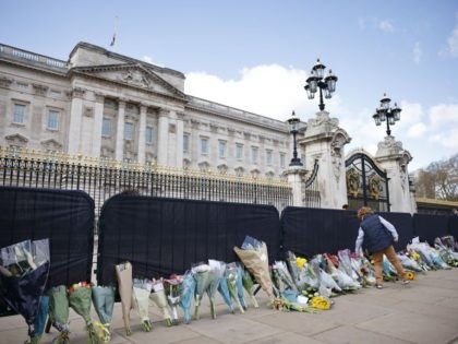 A well-wisher adds flowers to the tributes outside Buckingham Palace in central London, on April 11, 2021, two days after the death of Britain's Prince Philip, Duke of Edinburgh, at the age of 99. - The funeral of Queen Elizabeth II's husband, Prince Philip, will take place next week, Buckingham …