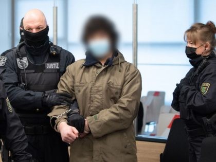 Defendant Abdullah A (C), accused of stabbing a German tourist to death in Dresden, is led by court officials into the hearing room of his trial at the Higher Regional Court in Dresden, eastern Germany, on April 12, 2021. - The trial of a Syrian jihadist who stabbed a German …