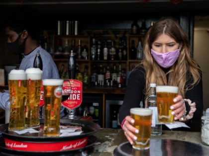 LONDON, ENGLAND - APRIL 12: Bar staff serve beer for table service in the garden of the The Duke of Kent pub which reopened at lunchtime today on April 12, 2021 in London, United Kingdom. England has taken a significant step in easing its lockdown restrictions, with non-essential retail, beauty …