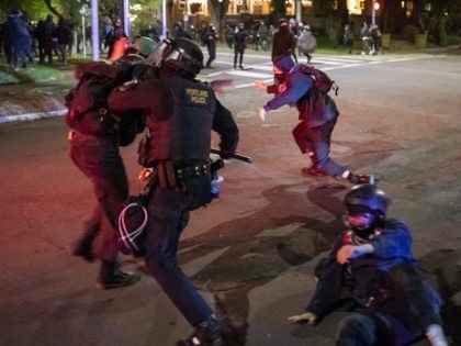 PORTLAND, OR - APRIL 12: A Portland police officers officer tackles demonstrators after a riot was declared during a protest against the killing of Daunte Wright on April 12, 2021 in Portland, Oregon. Wright, a Black man whose car was stopped in Brooklyn Center, Minnesota on Sunday reportedly for an …