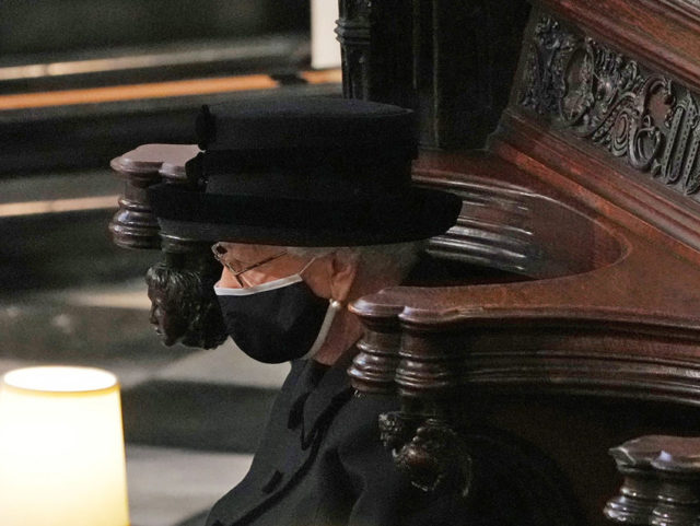 Britain's Queen Elizabeth II sits alone in the quire of St George's Chapel during the funeral service of her husband Britain's Prince Philip, Duke of Edinburgh in Windsor Castle in Windsor, west of London, on April 17, 2021. - Philip, who was married to Queen Elizabeth II for 73 years, …