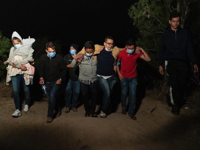 ROMA, TX - APRIL 22: Asylum-seeking migrants' families make their way to the location where they turn themselves in to the U.S. Border Patrol after crossing the Rio Grande river into the United States from Mexico on April 22, 2021 in Roma, Texas. A surge of mostly Central American immigrants …