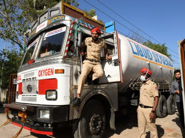 Police personnel prepare to escort a truck carrying medical liquid oxygen at the Guru Nanak Dev hospital amid Covid-19 coronavirus pandemic in Amritsar on April 24, 2021. (Photo by Narinder NANU / AFP) (Photo by NARINDER NANU/AFP via Getty Images)