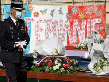 A policeman pays his respects in front of flowers laid in tribute to Stephanie Monferme, a