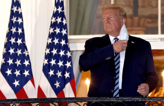 WASHINGTON, DC - OCTOBER 05: U.S. President Donald Trump removes his mask upon return to the White House from Walter Reed National Military Medical Center on October 05, 2020 in Washington, DC. Trump spent three days hospitalized for coronavirus. (Photo by Win McNamee/Getty Images)