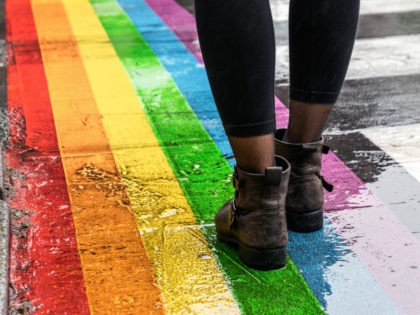 Female legs walking on rainbow crosswalk on Gay pride.