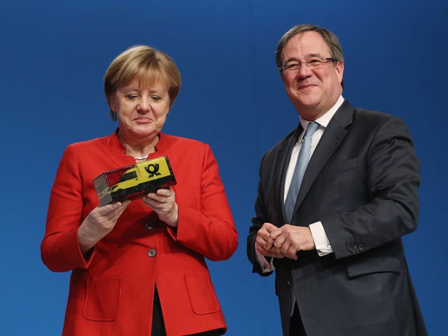 ESSEN, GERMANY - DECEMBER 06: German Chancellor and Chairwoman of the German Christian Democrats (CDU) Angela Merkel (L) receives a gift from CDU head in North Rhone-Westphalia Armin Laschet at the 29th federal congress of the CDU on December 6, 2016 in Essen, Germany. Approximately 1,000 CDU delegates are meeting …