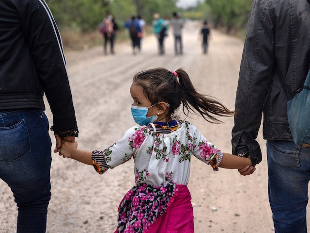LA JOYA, TEXAS - APRIL 14: An immigrant child glances back towards Mexico after crossing the border into the United States on April 14, 2021 in La Joya, Texas. Many Central American families who make the arduous journey describe their voyage as harrowing though the length of Mexico. Most pay …