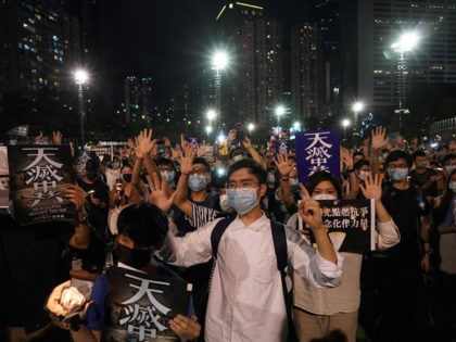 People gesture the popular protest slogan 'Five demands, not one less' as they attend a vigil in Victoria Park in Hong Kong on June 4, 2020, after the annual remembrance that traditionally takes place in the park to mark the 1989 Tiananmen Square crackdown was banned on public health grounds …