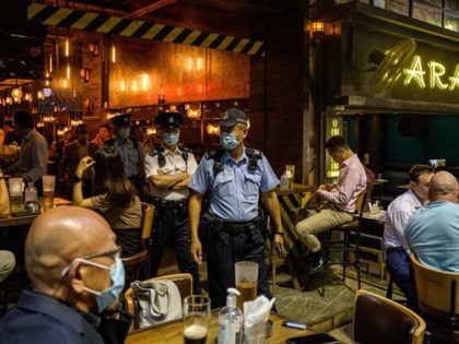 Food and Environmental Hygiene Department officers and police leave after inspecting the license of a restaurant and bar after it reopened, in Lan Kwai Fong, a popular drinking area in Hong Kong on April 29, 2021, as Covid-19 coronavirus social-distancing restrictions on restaurants and bars were eased under new vaccine …