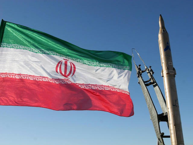 An Iranian flag flutters next to a ground-to-ground Sajil missile before being launched at an undisclosed location in Iran on November 12, 2008. Iran test fired today a new generation of ground-to-ground missile, the semi-official Fars news agency quoted the defence minister as saying. In the past Iran has often …