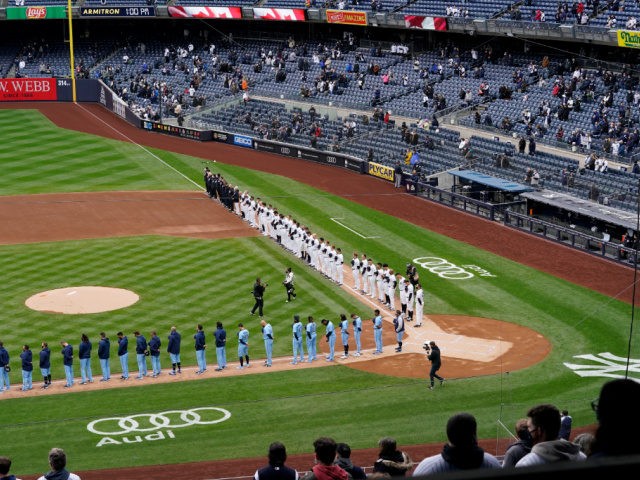 Players and coaches from the Toronto Blue Jays and the New York Yankees line up along the base paths during the singing of the National Anthem at the start of a major league baseball game on opening day at Yankee Stadium, Thursday, April 1, 2021, in New York. The announced …