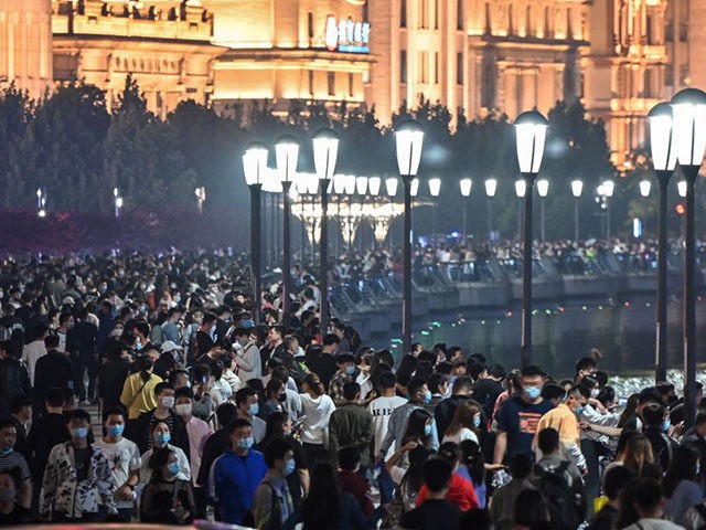 TOPSHOT - Large crowd of people wearing face masks visit the promenade on the Bund along the Huangpu River during a holiday on May Day, or International Workers' Day, in Shanghai on May 1, 2020. - With optimism and a heavy dose of caution, millions of Chinese hit the road …