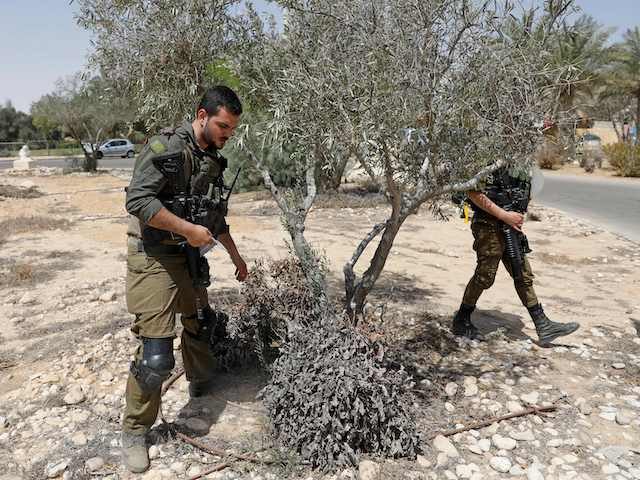 Israeli soldiers search for debris after a missile launched from Syria landed in Ashalim settlement, about 35Km south of Beersheva near the Dimona nuclear power plant in Israel's southern Negev desert, on April 22, 2021. - Multiple defence batteries in Syria were struck by Israeli forces, the military said, after …