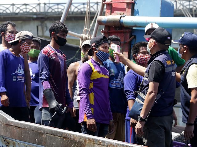 Immigration officers check the temperatures of Myanmar fisherman, as a preventive measure against the spread of the COVID-19 novel coronavirus, at the port in Pattani on April 11, 2020. (Tuwaedaniya Meringing/AFP via Getty Images)