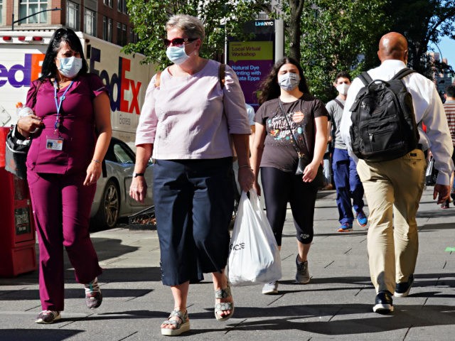 People walk while wearing protective masks as New York City moves into Phase 3 of re-opening following restrictions imposed to curb the coronavirus pandemic on July 14, 2020. Phase 3 permits the reopening of nail and tanning salons, tattoo parlors, spas and massages, dog runs and numerous other outdoor activities. …