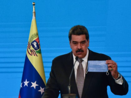 Nicolas Maduro President of Venezuela holds a protective facemask as he speaks in a press