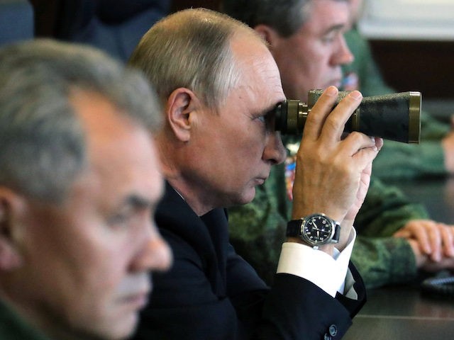 Russian President Vladimir Putin (C), accompanied by Defence Minister Sergei Shoigu (L), uses a pair of binoculars as he inspects the joint Zapad-2017 (West-2017) Russian military exercises with Belarus at the Luzhsky training ground in the Leningrad region on September 18, 2017. (Photo by Mikhail KLIMENTYEV / SPUTNIK / AFP) …