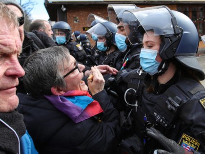 Police try to push back protestors who take part in a demonstration demanding the compliance of basic rights and an end of the restrictive coronavirus measures in Kassel, central Germany, on March 20, 2021. - Several thousand critics and so-called 'Querdenker' from all over Germany were expected to take part …