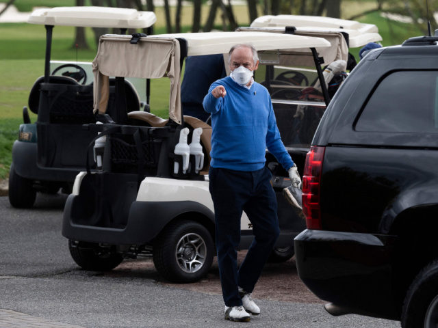 Counselor to the President Steve Ricchetti (C) gestures after playing a round of golf with