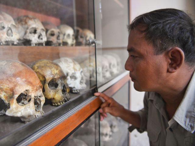 Norng Chan Phal, who survived internment at the Tuol Sleng prison known as S-21 as a child, looks at skulls displayed at the Tuol Sleng genocide museum in Phnom Penh on September 2, 2020. - Kaing Guek Eav, 77, better known by his alias Duch, the chief torturer behind Cambodias …