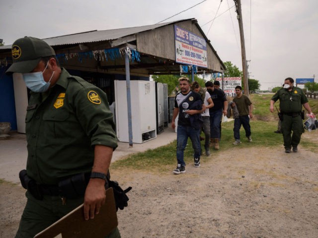 A group of migrants arriving from Mexico are detained by state troopers and border patrol agents at a roadside after they were apprehended in a vehicle after crossing illegally from Mexico in the border city of Rio Grande, Texas, on March 27, 2021. (Photo by Ed JONES / AFP) (Photo …