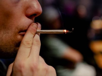 This photograph taken on April 22, 2019, shows a person smoking a cannabis "joint" in Cremers Coffee Shop in The Hague. - In the Netherlands, an experiment with state-regulated marijuana cultivation is starting. The aim of the experiment is to show whether "weed" can be removed from crime, but also …