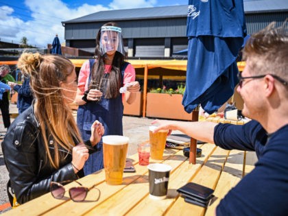 GLASGOW, SCOTLAND - JULY 06: Members of the public enjoy their first drink in a beer garden at SWG3 on July 06, 2020 in Glasgow, Scotland. Beer gardens across Scotland are permitted to reopen today, as the coronavirus lockdown restrictions are eased further in the country. (Photo by Jeff J …