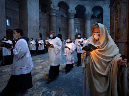 Priests circle the Edicule during Easter Sunday mass led by the Latin Patriarch at the Church of the Holy Sepulchre where Jesus Christ is believed to be buried, in the Old City of Jerusalem, Sunday, April. 4, 2021. (AP Photo/Oded Balilty)