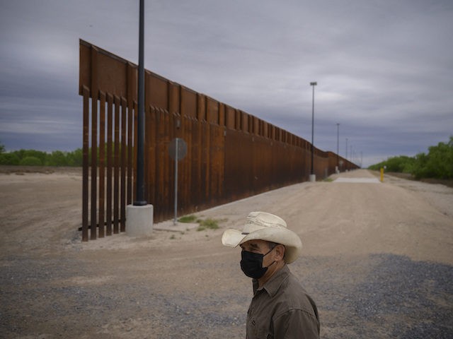 In a photo taken on March 28, 2021 ranch owner Tony Sandoval (67) stands before a portion of the unfinished border wall that former US president Donald Trump tried to build, near the southern Texas border city of Roma. - The 11,000 inhabitants of the Texas border town Roma have …