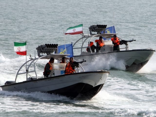 Iranian Revolutionary Guards drive speedboats during a ceremony to commemorate the 24th an