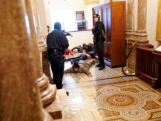 FILE - In this Jan. 6, 2021, file photo U.S. Capitol Police hold insurrectionists loyal to President Donald Trump at gun-point near the House Chamber inside the U.S. Capitol in Washington. A month ago, the U.S. Capitol was besieged by Trump supporters angry about the former president's loss. While lawmakers …