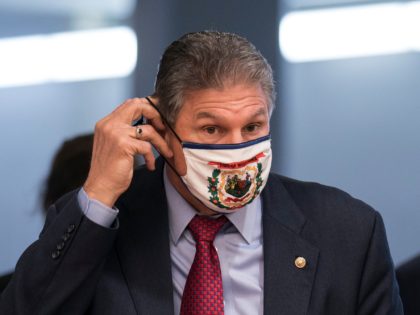 Sen. Joe Manchin, D-W.Va., adjusts his face mask as he arrives for votes on Biden administration nominees, at the Capitol in Washington, Tuesday, March 16, 2021. (AP Photo/J. Scott Applewhite)