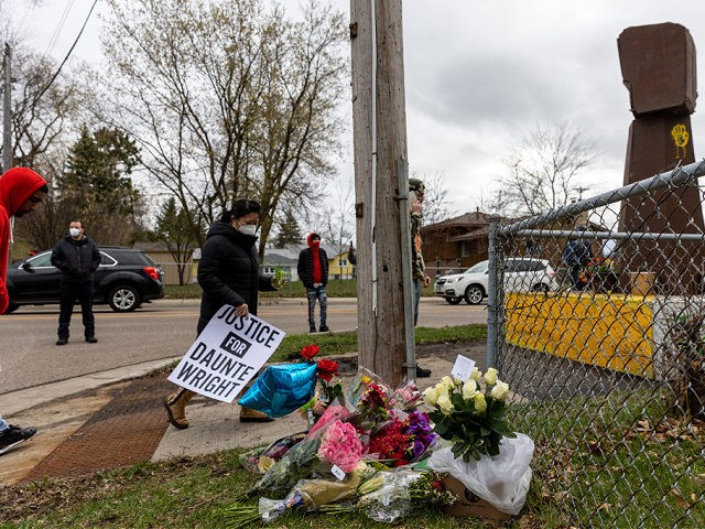 People bring flowers and signs during a vigil where Daunte Wright was shot and killed by a police officer in Brooklyn Center, Minnesota on April 12, 2021. - Fresh protests broke out Tuesday night in Minneapolis despite a curfew implemented after a police officer fatally shot a young Black man …