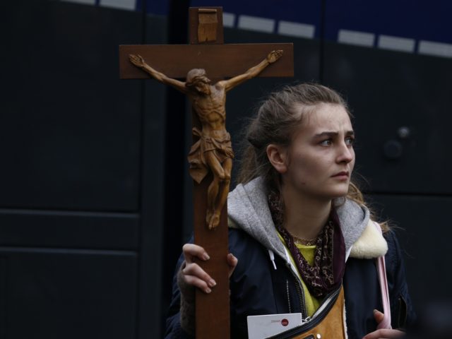 BERLIN, GERMANY - NOVEMBER 18: A demonstrator carries a christian Cross while she protests next to the Reichstag against modifications to a law called the "infection protection law" ("Infektionsschutzgesetz") prior to a vote on the law in the Bundestag during the second wave of the coronavirus pandemic on November 18, …