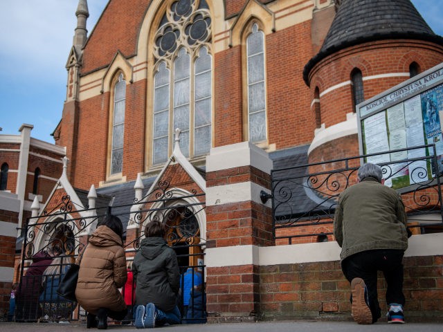 LONDON, ENGLAND - APRIL 04: Christians kneel outside during an Easter Sunday service due to lack of space indoors because of covid-19 social distancing guidelines at Christ the King church on April 4, 2021 in the Balham area of London, England. The church had its Good Friday service interrupted by …
