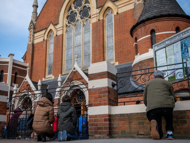 LONDON, ENGLAND - APRIL 04: Christians kneel outside during an Easter Sunday service due t